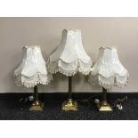 Three brass Corinthian column table lamps with shades