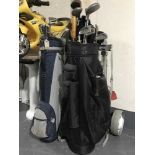 Three golf bags and assorted golf clubs with two folding trolleys