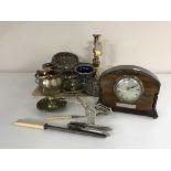 A tray of early 20th century eight day mantel clock, brass candlesticks, cutlery,