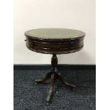 A mahogany leather topped drum table