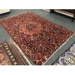 A Persian Heriz carpet on red ground 300 cm x 190 cm