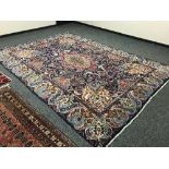 A large Persian carpet on blue ground,