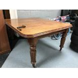 A Victorian wind out dining table with two leaves and handle