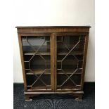 A mahogany glazed door bookcase on bracket feet