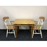 A pine kitchen table and two chairs