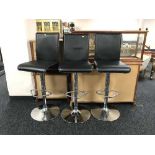 A set of three contemporary gas lift bar stools