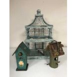 A decorative bird cage and two wooden bird boxes