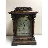 A carved oak chiming bracket clock with silvered dial