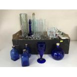 A box of assorted glass ware and two hurricane lamps
