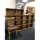 A large set of teak open shelves and an Ercol dining chair