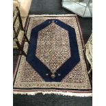 A fringed Persian Tabriz rug with central medallion on blue ground,