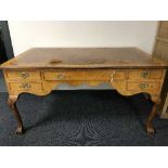 An antique walnut writing desk on claw and ball feet with tooled leather inset top