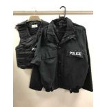 A large quantity of police clothing, badges, caps, black jumpers, white shirts, police work wear,