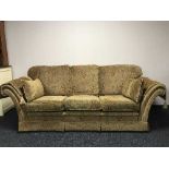 A three piece lounge suite in gold floral print