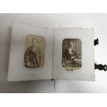 An antique tortoise shell photo album containing black and white photos