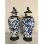 A pair of nineteenth century Chinese blue and white glazed lidded vases with character marks to