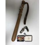 A policeman's truncheon and a bag of cased defence medal and two whistles