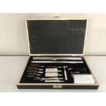 A gun cleaning kit in fitted wooden box