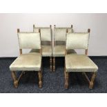 An antique oak dining table and four chairs in beige fabric