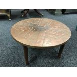 A circular copper topped table by Raymond Hodgkiss and company