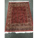 A Persian Bokhara rug on red ground,