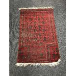 An Afghan prayer rug on red and black ground