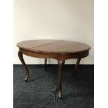 An early 20th century mahogany extending dining table with leaves and five chairs