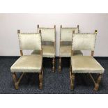 An antique oak dining table and four chairs in beige fabric