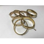 A collection of seven 9ct gold metal core bangles, one gold on silver.