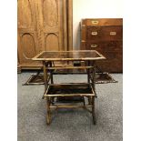 A Victorian aesthetic period lacquered bamboo occasional table, with four fold-out panels,