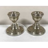 A pair of loaded silver dwarf candlesticks