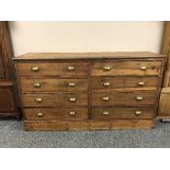 A pine draper's side-by-side chest of eight drawers, with brass handles, width 168 cm.