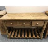 A reclaimed pine table fitted with three drawers, width 135 cm.