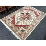 A fringed Persian Heriz rug, on red ground, 230 cm x 160 cm.