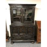 A 19'th Century carved oak coffer, with glazed double-door cupboard above, width 108 cm.