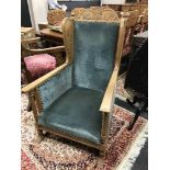 A Continental carved oak wingback easy chair, upholstered in blue velvet.
