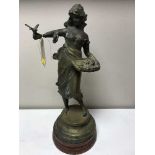 A spelter figure a lady with a bird on a metal base