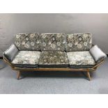 An Ercol elm three seater settee or day-bed