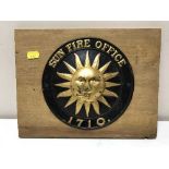 A tin Sun Fire office insurance plaque mounted on pine board