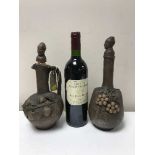 Two pottery decanters embossed with grapes and a bottle of Chateau Tour du Vieux Castel 1998 Saint