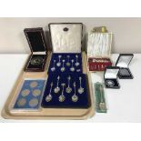 A tray of cased Exquisite tea spoons, set of United Kingdom commemorative crowns, a five pound coin,