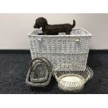 A large wicker hamper containing wicker and metal baskets, wall rack,