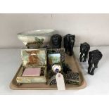 A tray of carved ebony elephant ornaments, desk clock with photo frame, pill box, perfume bottle,