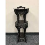 A Chinese carved three tier stand with rouge marble top,