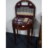 A Victorian inlaid mahogany d-shaped canteen containing a set of stainless steel and plated cutlery