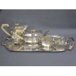 A silver Art Deco four piece tea service and tray, together with a small pair of silver sugar nips,