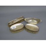 A pair of silver backed dressing table brushes together with a small silver dish and a further