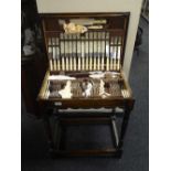 An oak cutlery table containing a John Sanderson & Son of Sheffield cutlery set