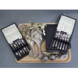 A silver backed mirror and dressing table brush together with four cases of silver plated cutlery,