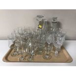 A tray of assorted drinking glasses, claret jug and a decanter, preserve pots,